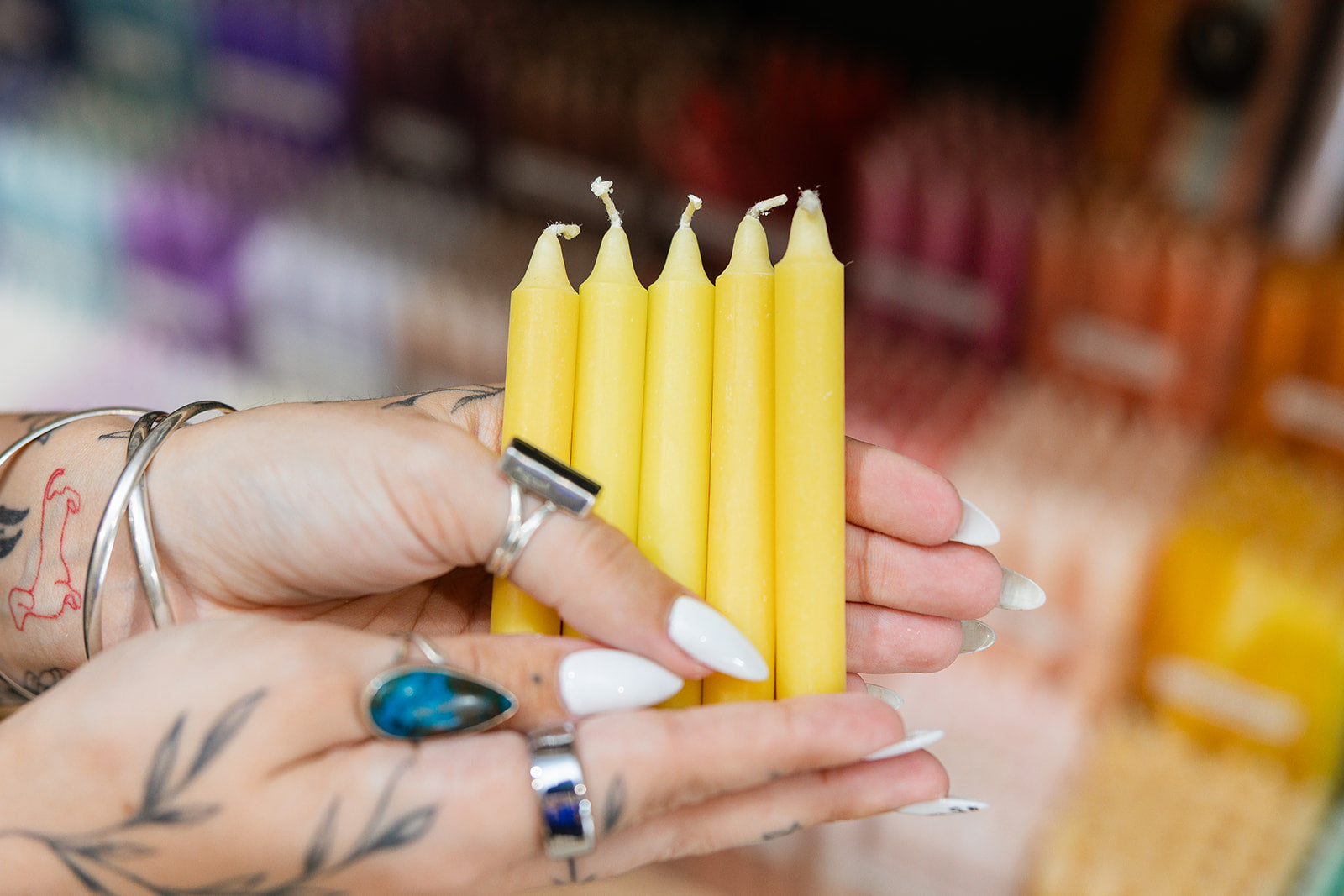 Hands holding five yellow candles with a blurred background